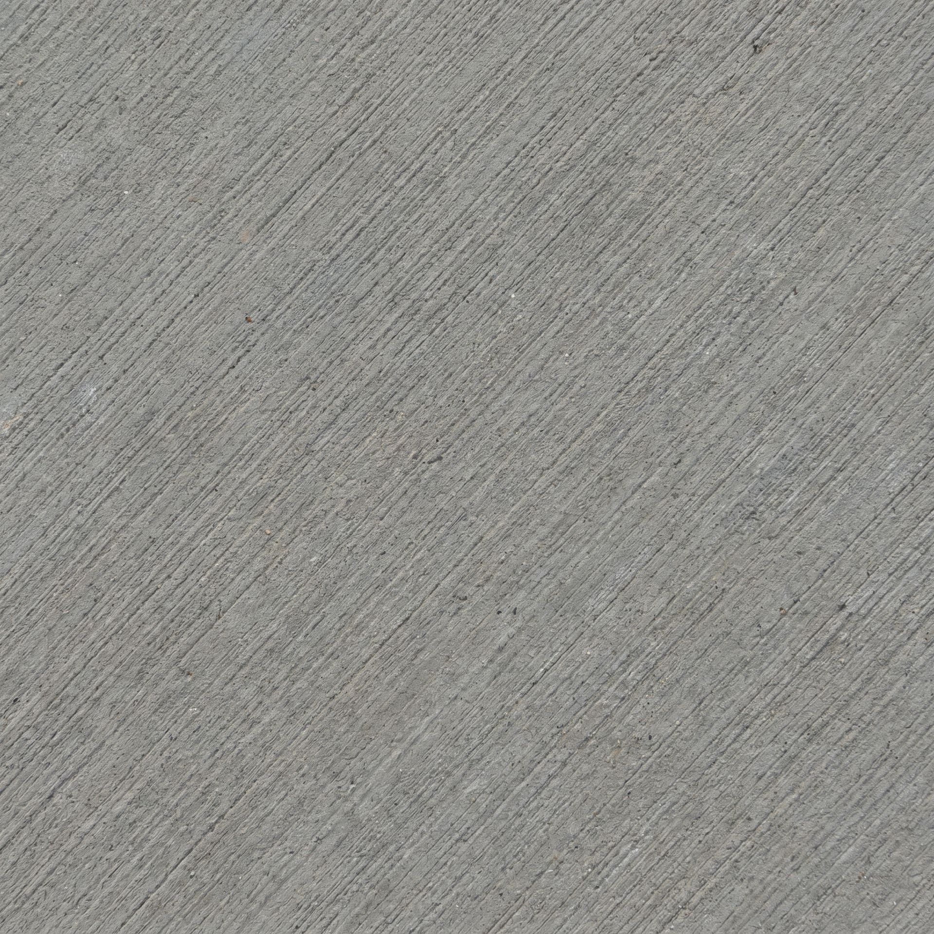 Close-up detail of a freshly broom-finished concrete surface with parallel brush striations on medium-gray concrete