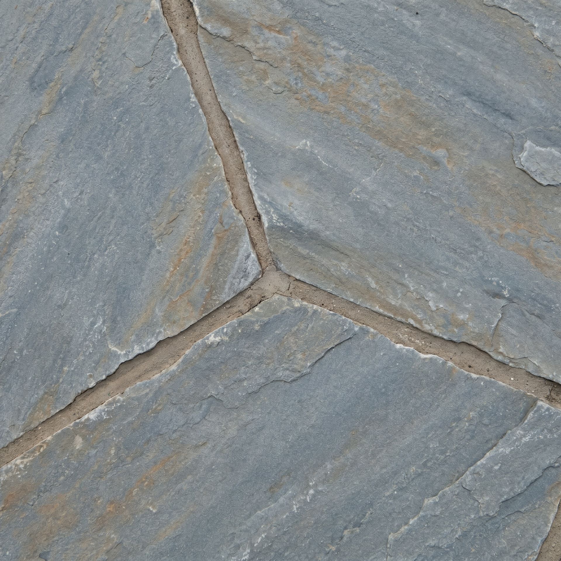 Close-up detail of natural Pennsylvania bluestone flagstone with a thermal finish and recessed mortar joints between irregular bluish-gray slabs